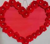 Paper made heart frame by red roses